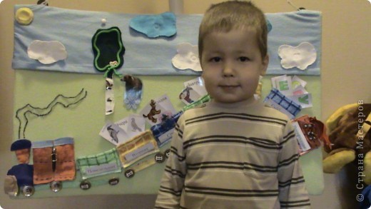 Панно используем для календаря погоды - дождик (снег) на пуговках из тучи;закрепили понятия "день-ночь" - пока не пропал интерес солнышко ложилось спать в вагончик а на его место появлялась луна.Учим времена года - появляются элементы: зимой - сугробы и берлога(там спят медведь и ежик), весной - цветочки, летом - бабочки и мальчик с сачком, осень - цветные листья. Все это крепится на кнопках. Недавно обнаружили, что объемные наклеки неплохо живут на нашей ткани - в результате появились пчелки и птички. А если панно перевернуть, то получим экран для фланелеграфа (но это уже другая страничка). (фото 2)