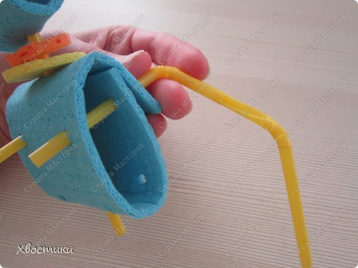 Мы же хотим, чтобы наш робот умел двигать руками в любом направлении! Тогда приступим к сборке рук.
Берём трубочку для рук. Более короткую ее часть (2.5 см) складываем ВДОЛЬ и просовываем внутрь трубочки-руки, которая у нас торчит из спины робота. Видите на фото: я сложила трубочку и засовываю её внутрь другой трубочки. (фото 16)