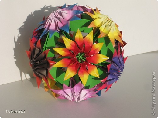 Оригинал здесь - http://ru-kusudama.livejournal.com/651777.html?page=2&cut_expand=1#cutid1.

Ох и тяжко она мне далась! 120 модулей на цветочки! Больше трех цветов за день никак не складывались, хотя времени уходило совсем немного. Просто модули оказались какими-то "надоедливыми" что-ли... (фото 2)