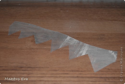 Попробую объяснить как я сделала "шлейф". Берем небольшую полоску органзы и ножницами вот таким зигзагом обрезаем один край. (фото 10)