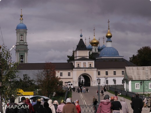 А это наша группа дружно направляется в Свято-Введенскую Оптину Пустынь. Вид с автобусной стоянки. 
Немного истории.
Оптина пустынь, без преувеличения, – наиболее жаркая свеча,  наиболее яркий светильник Православной Руси в ХIХ-ХХ вв. По преданию, основан в конце XIV века раскаявшимся разбойником по имени Опта (Оптия), в иночестве — Макарий. До XVIII века материальное состояние монастыря было тяжелым. В 1773 году в монастыре было всего два монаха — оба глубокие старики. В конце XVIII века обстановка изменилась. В 1821 году в монастыре был устроен скит. Здесь селились особо сподобившиеся «пустынники» — люди, которые многие годы провели в совершенном уединении. Всей духовной жизнью монастыря стал ведать «старец» (настоятель оставался администратором). Со всех сторон к монастырю потянулись страждущие. Оптина стала одним из духовных центров России. Стали поступать пожертвования; монастырь приобрел угодья, мельницу, обустроил каменные здания.
*********************************************
С Оптиной пустынью связаны эпизоды в жизни некоторых писателей и мыслителей России. В.С. Соловьев привёз Ф. М. Достоевского в Оптину после тяжелой драмы — смерти сына в 1877 году; он прожил в скиту некоторое время; некоторые детали в «Братьях Карамазовых» возникли под впечатлением этой поездки. Прототипом старца Зосимы явился старец Амвросий (прп. Амвросий Оптинский, канонизирован в 1988 году), живший в то время в скиту Оптиной пустыни. Сестра графа Л.Н. Толстого Мария Николаевна Толстая была насельницей основанного рядом старцем Амвросием женского Шамординского монастыря, где она и скончалась, за три дня до смерти приняв монашеский постриг.
23 января 1918 года декретом СНК Оптина пустынь была закрыта, но монастырь ещё держался под видом «сельскохозяйственной артели». Весной 1923 года закрыли сельхозартель, обитель перешла в ведение Главнауки. Как исторический памятник была названа «Музей Оптина пустынь». В 1939—1940 годах в Оптиной пустыни содержались польские военнопленные (около 2,5 тыс. человек), многие из которых позже были расстреляны. В 1987 году монастырь был возвращён Русской православной церкви.
Главной же святыней обители были ее прославленные боголюбивые старцы, сияние жизни которых продолжает освещать жизненный путь очень многих. (фото 17)