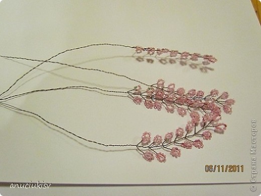     Бисер покупала 4 цветов перламутровый (светло розовый,  розовый, малиновый и зелёный). Зелёного только один мешочек а остальной по 2 мешочка.  Проволока 0,3 мм коричневая.  Выбрала бисер а потом уже к нему подбирала проволоку, что бы бисер легко нанизывался. (Если бы бисер был бы побольше то и проволоку взяла бы потолще).
    Весь бисер смешала в одной чашке и нанизывала на проволоку. 
    Наплела много вот таких веточек. (фото 2)
