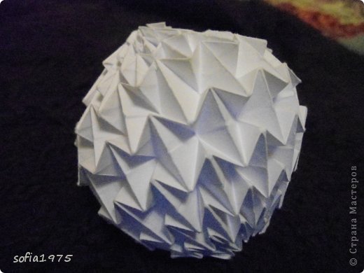 Origami Magic Ball (Dragon's Egg by Yuri Shumakov) .Вовсе не кусудама,а очень неудобный в складывании шар из цельного листа бумаги.Но когда понимаешь принцип складывания-дело начинает продвигаться.Из этого шара получается замечательный фонарь на новогодней ёлке,если поместить в его середину лампочку гирлянды. (фото 2)