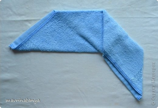 Переверните трапецию таким образом, чтобы короткая сторона была вверху. Сложите первый уголок на левую сторону по направлению к центру нижней свернутой стороны. (фото 10)