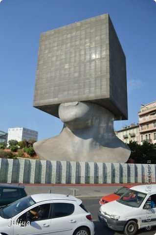 В Ницце, воспетой многими писателями, стоит "La Tete au Carre" ("мышление в коробке") или Кубическая Голова, неожиданное во всех отношениях здание, предназначенное для городской библиотеки.
А виноват во всем французский скульптор и живописец с международной известностью - Саша Сосно (Alexandre Joseph Sosnowsky, родился в 1937 году), соорудивший под заказ в Ницце оригинальную скульптуру. И в результате полета мысли скульптора, в Ницце появилось здание в виде стилизованной головы – шея и нижняя челюсть вполне так человеческие, а все, что выше представляет собой монолитный куб. Высота всего сооружения составила примерно 27 метров (7 этажей), причем большая часть приходится как раз на «кубик», который внутри разбит на ярусы. Построена в 2002 году. (фото 31)