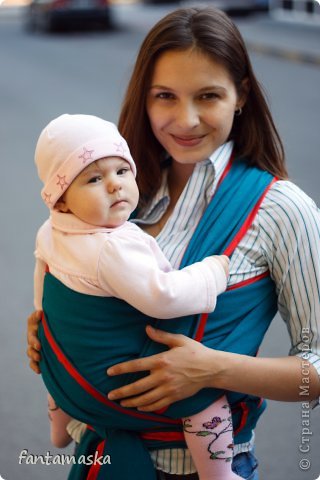 Как-то оставили у нашей бабушки наш рюкзак-кенгуру. Зная, что забрать сможем только через неделю, решила купить слинг. Начиталась множество разной информации, остановилась именно на слинге-шарфе. Но, узнав цену, решила сшить сама. У свекрови была ткань зеленая, плотная, не тянущаяся( состава не знаю, лежала со времен СССР). 4 метра длиной и 1 метр шириной. На слинг-шарф нужно где-то 6 м х 70 см. Отрезала 30 лишних сантиметров от ширины и пристрочила их к краям будущего слинга, получились очень удобные завязки. Края обработала красной атласной лентой, понадобилось где-то 15 метров ленты 2,5 см шириной. Очень удобная штучка, тем более сами завязки получились уже, чем весь слинг, всего 30 см шириной и завязывать его гораздо удобнее, чем магазинный( узел меньше). А еще можно на середину слинга пришить какую-нибудь нашивку, чтобы легче его было завязывать. (фото 1)