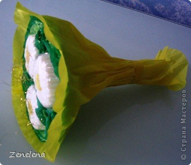 Для упаковки использовала креповую бумагу (просто бумага, не та, в которую цветы упаковывают). Она, конечно тонковатая, но для упаковки, по-моему, годится.
Основа для букета: картонный большой круг и 3 маленьких картонных кружочка. Сначала оформила оборочками каждый кружочек, потом - сам большой круг. И приклеила к нему твердую трубочку от фольги или пищевой пленки (уже не помню, что на нее было намотано). А потом соединила кружочки-розеточки с большим кругом, в промежутках тоже приклеила маленькие завитушки из креповой бумаги и завернула все в желтую бумагу. (фото 4)