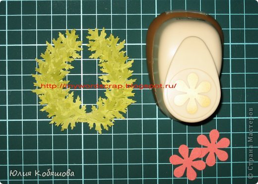 Вот наш венок и почти готов. Для того, что бы его сделать более интересным смастерим еще цветок пуансетии.
 1. На этот раз нам потребуется дырокол цветочек. Им вырезаем 2 цветочка красного цвета. (фото 10)