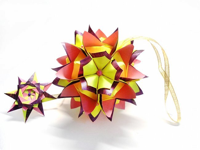 Name: Cleopatra
Designer: Maria Sinayskaya  

Diadem kusudama https://www.flickr.com/photos/51642560@N02/5096622060/in/set-72157624275437833/

Variation: Uniya Filonova
Parts: 30 + 60

Paper: 7,5 x 7,5 + 3,75 x 3,75
Final height: ~ 8,5 cm

Туториал https://podjem-tal.ru/node/796019 (фото 3)