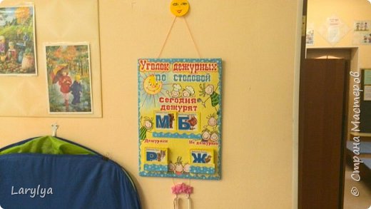 Вот так выглядит уже на своём месте в детском саду. Размер 45 х 60 см. Коробочки для букв, взяты из под лекарств, обклеила так же обоями и раскрасила, приклеила на клей "момент" прозрачный. Буквы по середине вставляются в кармашек из картона. (фото 5)