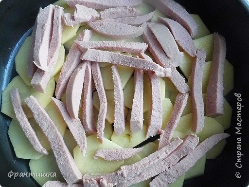 Дно формы смазала маслом, картофель очистила, нарезала кружочками и выложила в виде чешуи, сверху положила остатки кобаски вареной (фото 2)