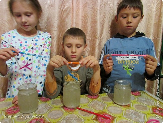 С кипятком нам помогал папа, наливаем его в банки, и добавляем соль. примерно 15-16 чайных ложек на одну неполную поллитровую банку кипятка... Размешиваем.  У нас соль вся не растворилась... на дне осталось немного.   так и надо...    Раствор у нас получился мутным... Если вы используете белые пушистые палочки, то растрор обязательно надо перелить через несколько слоёв марли в друрую банку... Мы не фильтровали, дети не захотели... Ну для разноцветной синельки это не страшно, а вот для белой... Белая снежинка у нас получилась не красивая... Следующий раз обязательно будем отфильтровывать...
 Теперь опускаем наши снежинки в солевой раствор... (фото 7)