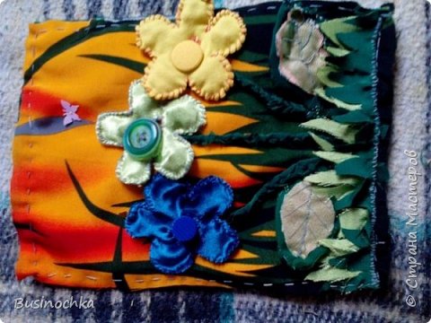 Цветочки)) Цветочки с дырочками и снимаются с пуговок, местами можно менять. Пуговки все разные: самая большая зеленая гладкая с впадинкой, средняя желтая - покрыта тканью, маленькая линяя - рефленая)) В цветочках разные наполнители: в синем бисер, желтом бусины, в зеленом пуговки) Листики шелестят, в травке спрятана бабочка. ножки цветочков - тканевая косичка, пришиты только в двух местах)) (фото 6)