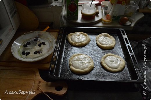 Некоторые кладут ватрушки тесно и они смыкаются краями. Я предпочитаю чтоб ватрушка румянилась со всех сторон и снаружи была похрустящее. А внутри пышно-нежной. Поэтому раскладываю лепёшки на расстоянии друг от друга около 4-5 см, потом сдвигать тяжело, кладите аккуратно.  Окончательно пальцами формирую валик по краям, чем тоньше дно ватрушки, тем лучше, а то тесто под творогом останется сырым. Легко переборщить, особенно если делать выемку не пальцами, а бокалом, стаканом. Начинка будет вытекать и подгорать, если промнёте до дыр. Лепёшки стремятся принять изначальный вид, уж такое свойство дрожжевого теста, перед начинкой первые лепёшечки требуют коррекции пальчиками. 
Кладём начинку, около одной столовой ложки на одну плюшку. Начинка не должна быть холодной, тесто опадёт. Если увидите в первой ватрушке, что начинка жидковата, не стоит пологой горкой, течёт – добавьте в массу чуть крахмала. 
 (фото 28)