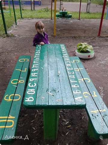 А вот со столом я долго думала, что же нарисовать. Сначала решила нарисовать какую-нибудь яркую картинку на весь стол. Потом передумала заморачиваться, так как и так "прожила" на площадке ни один день, да и просто не успевала в срок. Решила что-то попроще. На ум приходили только цветочки, бабочки, или просто геометрические фигуры. Но цветочков и кружочков уже было достаточно на других участках. Придумались буквы и цифры. И ни как у всех, и развивалка для детишек.Мы ведь пока манюни, но скоро уже начнем изучать буквы и цифры. Как раз пригодится. Я в принципе довольна. Только не ярко, зато аккуратно и не наляписто.  (фото 13)