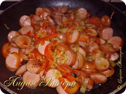 В кипящую подсоленную воду чистим и нарезаем кубиками картофель, кладем, лавровый лист, душистый перец, приправы и варим до готовности картофеля.
Лук жарим на растительном масле до золотистого цвета, добавляем болгарский перец. Солим, перчим.
Копченые сосиски нарезаем кружочками и добавляем к луку с перцем. Обжариваем.   (фото 4)
