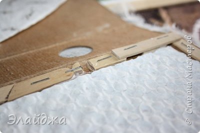Когда все высохло на стороне где будет полочка наклеиваю рифленую бумагу (у меня упаковка от конфет) и делаю карандашем разметку, где полки проходят и по контуру степлером (мебельным) прикрепила палочки от мороженного, делая промежутки там, где будет проходить линейка-планка. Так делаю основу из палочек от мороженного в 2 слоя. На обратной стороне папки кончики скоб загибаю , чтоб было ровненько. (фото 4)