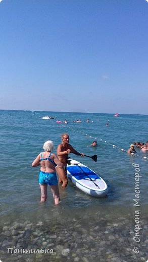 Море успокоилось и мы снова плавали и загорали...но рядом были молодые двое ребят,которые занимались плаванием на досках,Маша и Костя.Было много желающих и они в начале консультировали,проводили инструктаж и отправляли желающих покататься. И вот моя Екатерина пошутив с Костей вдруг решила тоже отправится в море на доске. Костя ей помогал,объяснял как надо встать и плыть. (фото 8)