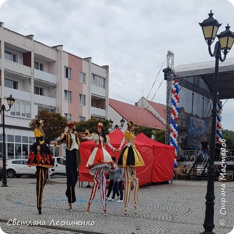 На против нас была сцена . Так что мы видели всю программу . Было очень весело и программа была хорошая. 
Вот такие дамы и кавалер ходили на ходулях. 
Вот КАК, КАК  они это делают . Я восхищаюсь. (фото 12)