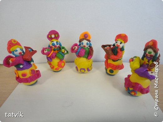 Среди современных русских глиняных игрушек самой большой известностью и популярностью пользуется дымковская (в прошлом вятская) игрушка. Это обобщенная, декоративная глиняная скульптура, близкая к народному примитиву: фигурки высотой в среднем 15-25 см, разукрашенные по белому фону многоцветным геометрическим орнаментом из кругов, горохов, полос, клеток, волнистых линий, яркими красками, часто с добавлением золота. 
Именно из- за своей яркости дымковские фигурки очень нравятся детям. 
Мы с девочками решили слепить вот таких куколок на основе футляра от киндер-сюрприза. Он очень похож на юбку-колокол дымковской барыни.  (фото 1)