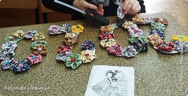 Приклеивает цветы к картонным цифрам. (фото 7)