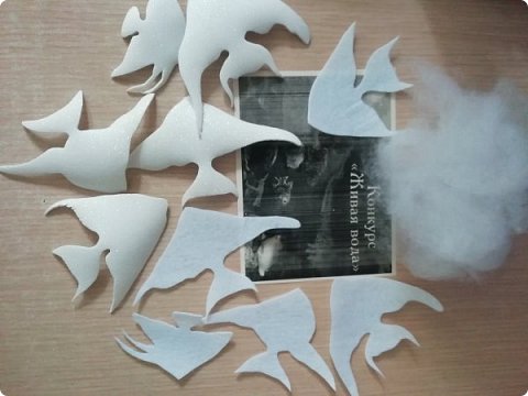 Для того, чтобы рыбки стали объёмные, мы пологрели их на утюге, блестящей стороной вверх. Из белого фетра вырезали подложки для рыбок по форме каждой рыбки. (фото 5)