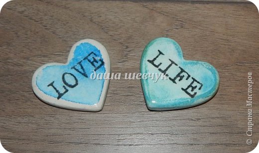 Сердечки из гипса, использовала силиконовую форму для выпечки. Затем красила, использовала гуашь и акварель. Надписи распечатала на салфетке (трехслойную салфетку разделила), клеила на разведенный ПВА. И завершающий этап - несколько слоев лака на водной основе. (фото 8)